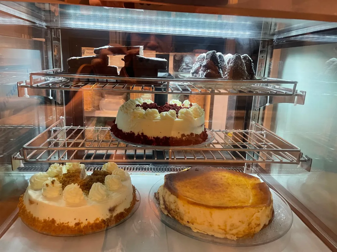La vitrina iluminada, con la tarta red velvet, la de zanahoria, la de queso y los dulces del día