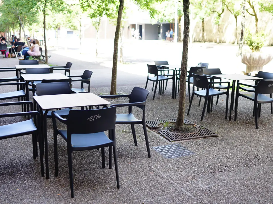 Las mesas de la terraza de Eli Kafea bajo los árboles de Latsunbeberri