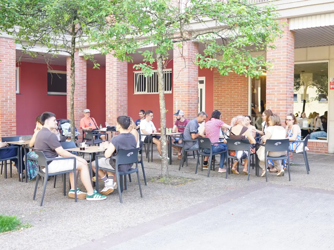 La terraza de Eli Kafea llena de gente frente a los soportales de ladrillo